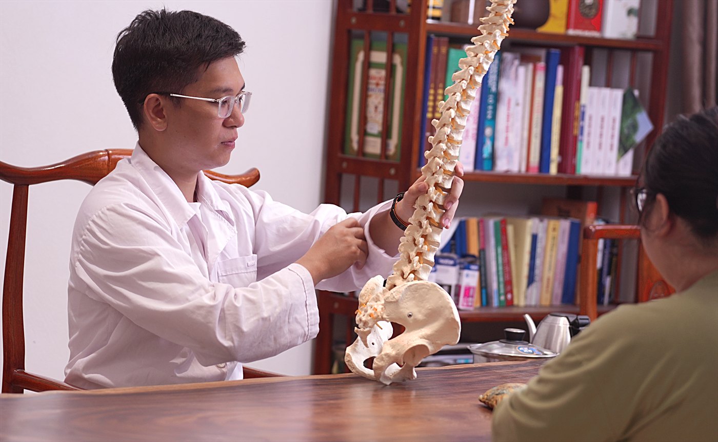 Bác sĩ Tùng giảng giải cho bệnh nhân bằng mô hình cột sống